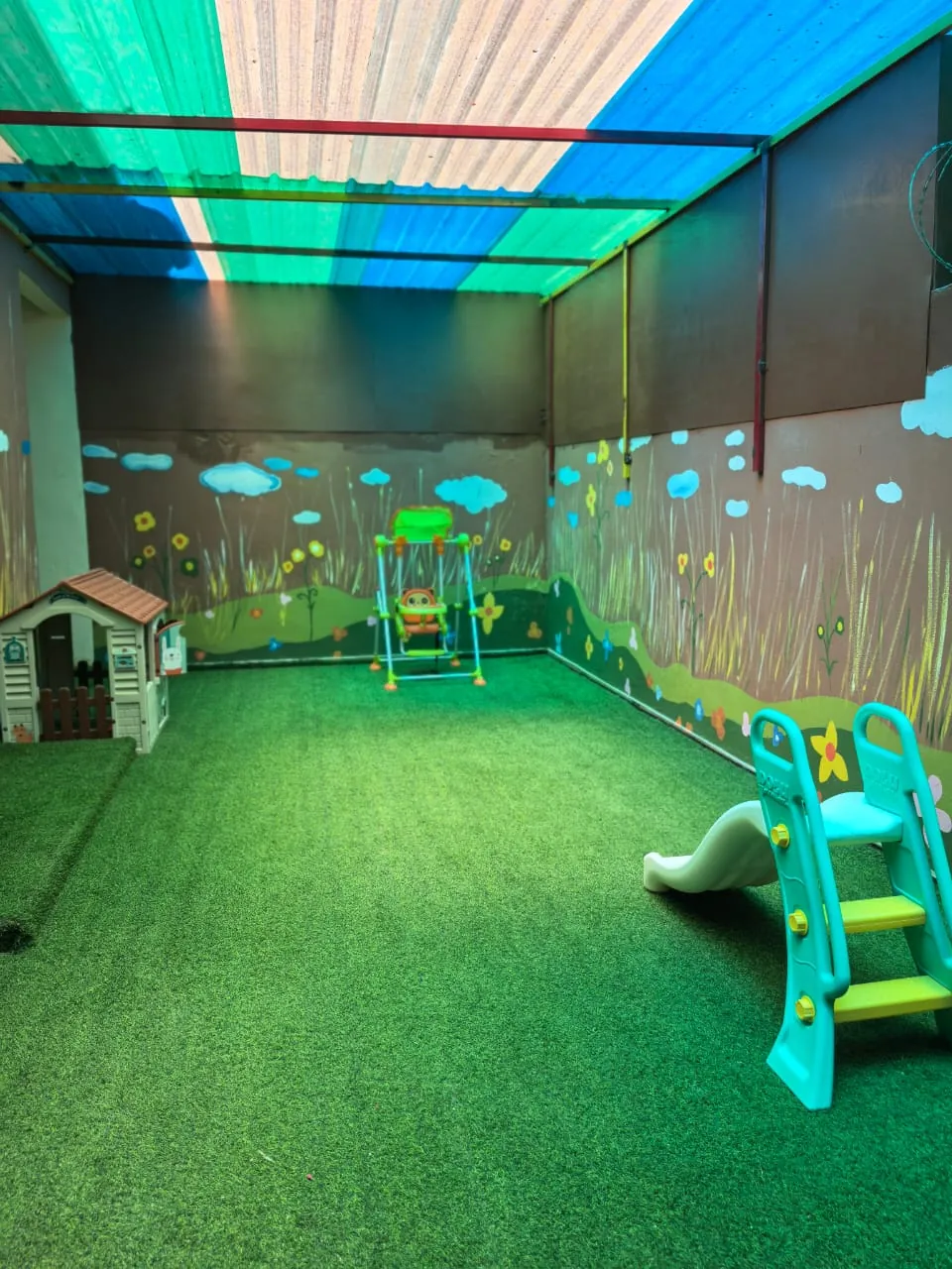 Aire de jeux et jardin de la crèche avec toboggan et gazon